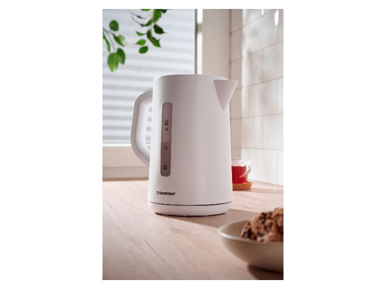 Witte SilverCrest waterkoker op een houten aanrecht met een kopje thee.