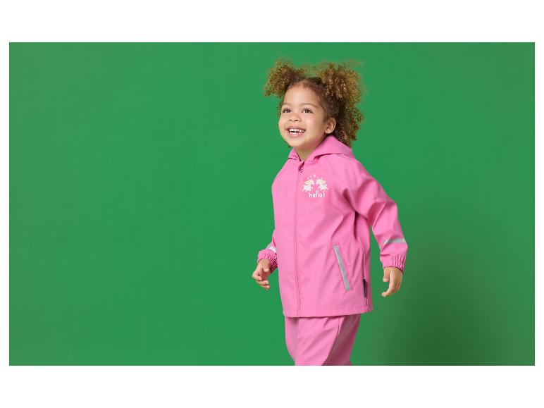 Klein meisje in roze regenpak met eenhoornmotief en de tekst 'hello!'