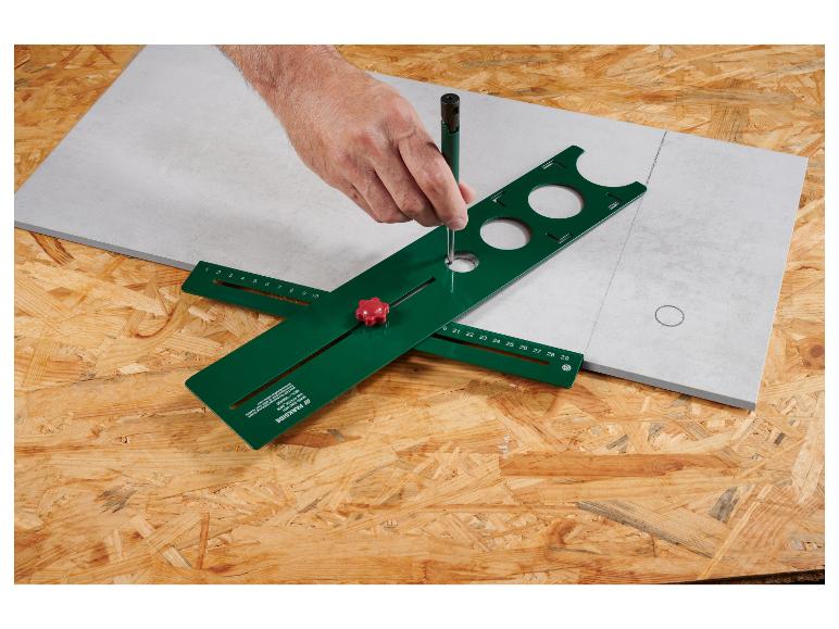 Een groene Parkside tegelboor met verschillende cirkelmaten en een liniaal.