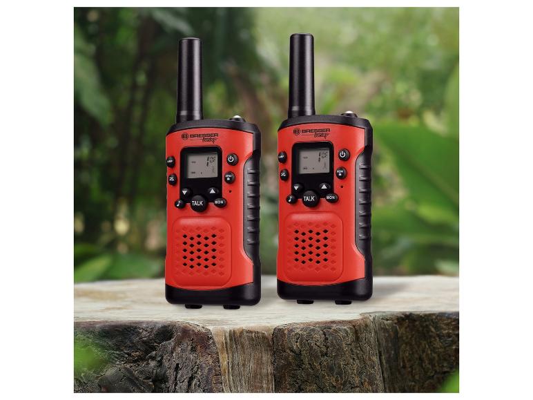 Twee rode Bresser Junior walkie-talkies op een boomstronk.