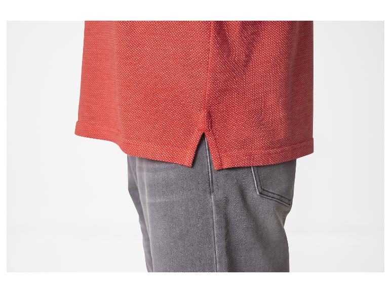 Rode polo en grijze jeans.