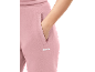 Close-up van roze joggingbroek met een hand in de zak.