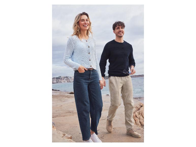 Een vrouw en een man dragen casual kleding, inclusief een gebreide trui en jeans.