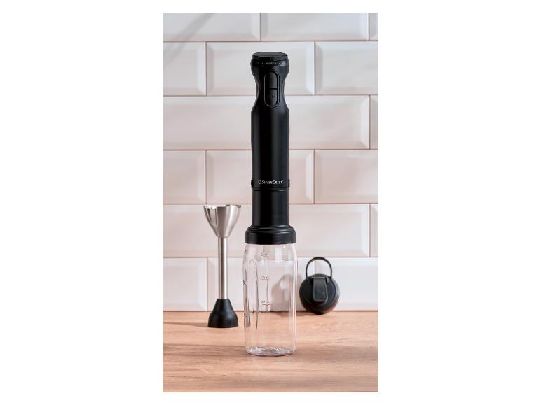 Zwarte SilverCrest staafmixer met maatbeker en garde op een houten aanrecht.