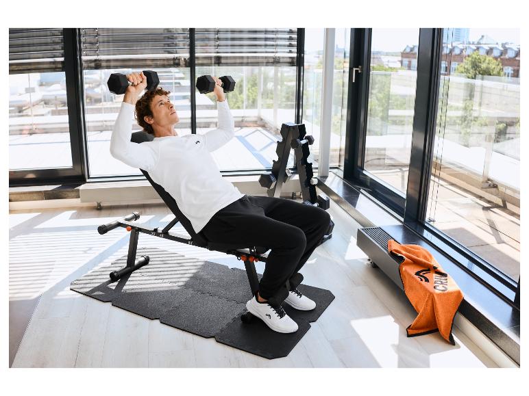 Man traint met dumbbells op CRIVIT vloerbeschermingsmat.