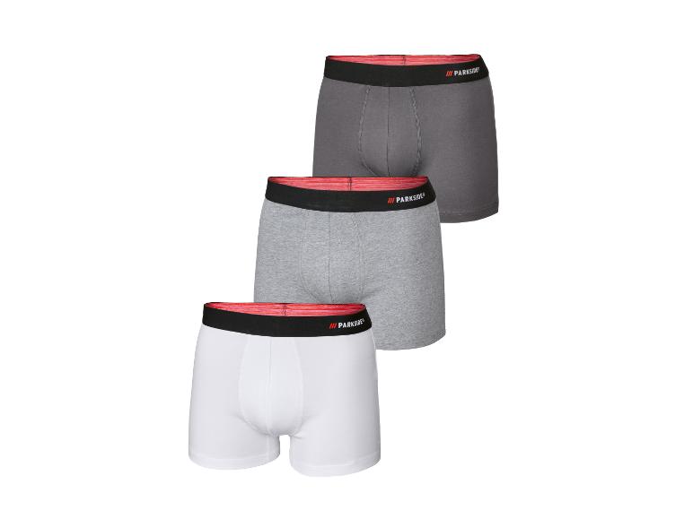 Drie Parkside boxershorts in grijs, lichtgrijs en wit met een rode en zwarte tailleband.