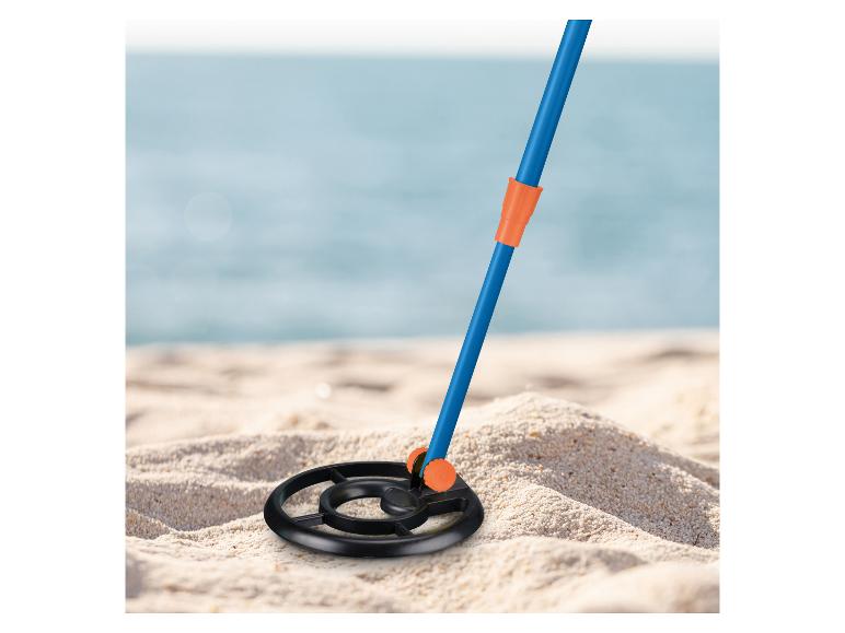 Metaaldetector op een zandstrand met de oceaan op de achtergrond
