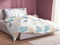 Beddengoed met geometrisch patroon in beige, groen en zwart.