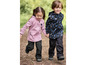 Twee kinderen in zwarte softshell broeken en jassen met robot- en dierenprint lopen hand in hand.