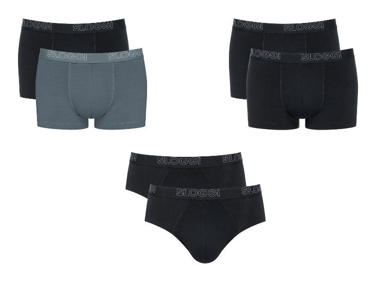 Drie sets herenondergoed: twee boxershorts sets (zwart en grijs, en volledig zwart) en één zwarte slip set.