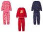 Drie sets kinderkerstpyjama's: roze met teckels, rood met rendieren en marineblauw met zuurstokken.