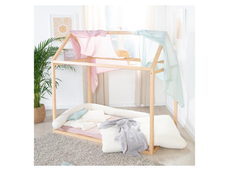 Houten huisbed met roze en blauwe luifel, planten en wanddecoratie.
