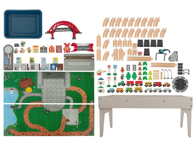 Houten treinspeelset met rails, voertuigen, gebouwen en accessoires, plus een speeltafel.