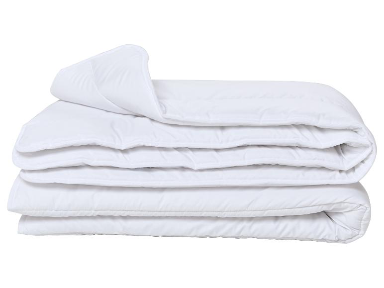 Opgevouwen wit dekbed of dekbedovertrek op een witte achtergrond.