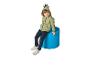 Lachend kind in een groene dinosaurus hoodie en jeans, zittend op een blauwe kruk.