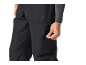 Close-up van een persoon die de rits van een zwarte outdoorbroek aanpast.