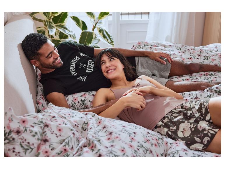 Ontspannen stel in bed met bloemetjes beddengoed en bijpassende pyjama's.