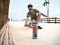 Draagbare blender met smoothie op de stoep, met man op skateboard op de achtergrond.
