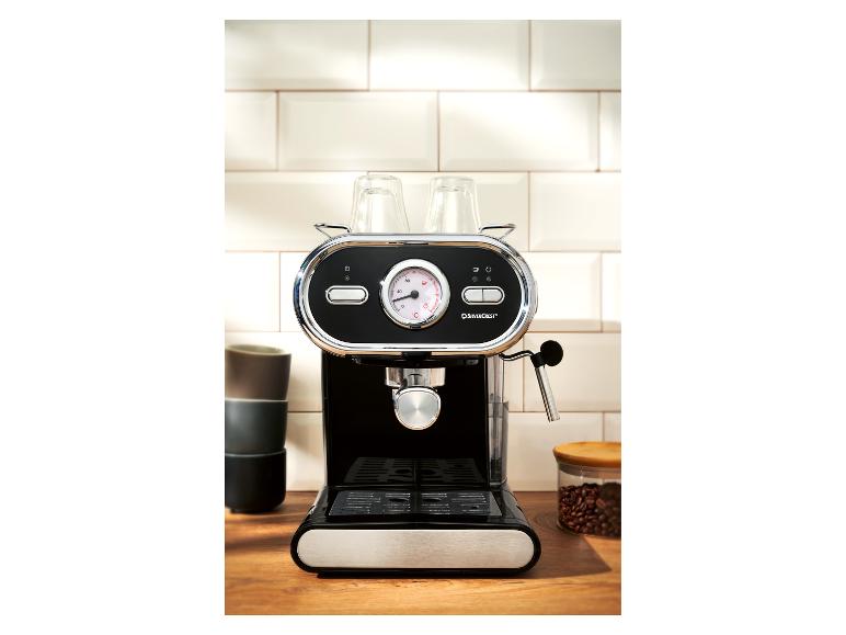 Zwart-zilveren espressomachine met kopjes erop, op een houten aanrecht.