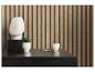 Modern bureau met wit abstract beeld, vetplant in pot en potlood tegen een houten lattenwand.