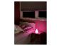 Kind slaapt in bed met een roze konijnenlampje op een nachtkastje.