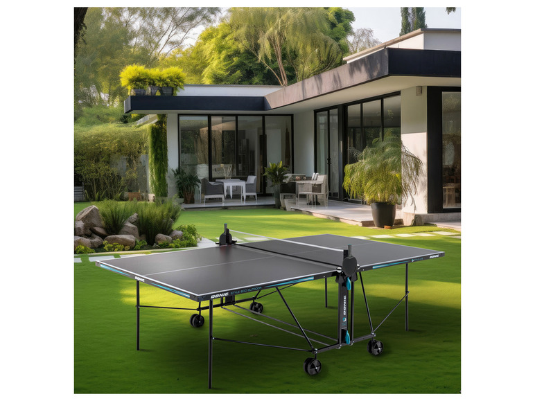 Een zwarte tafeltennistafel van Donic Style 800 Outdoor in een tuin.
