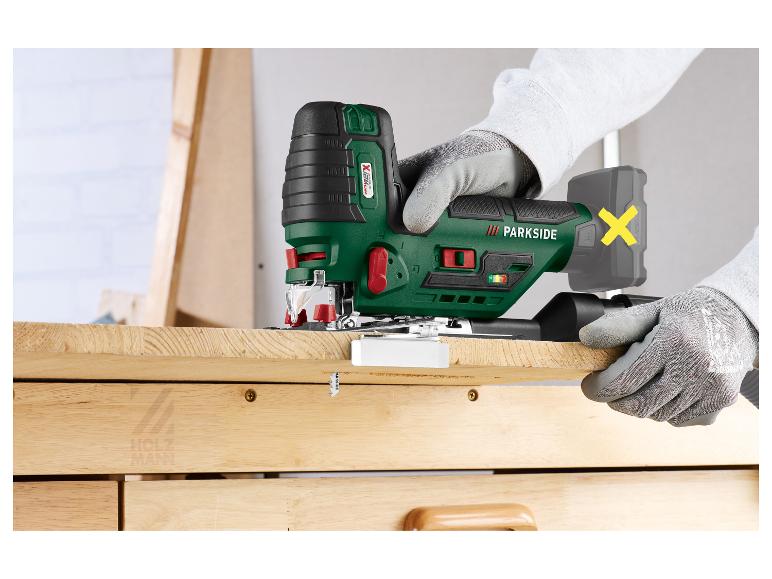 Accu decoupeerzaag in gebruik, hout zagen, met gehandschoende handen.