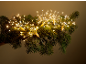 Warmwitte LED-sterrenlichtjes op een groene dennenkrans, die een feestelijke gloed creëren.
