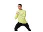 Man in neongeel sportshirt met lange mouwen en zwarte legging, aan het sporten.