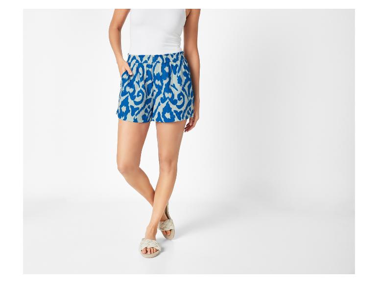 Geometrisch bedrukte shorts en platte sandalen: zomerse look.