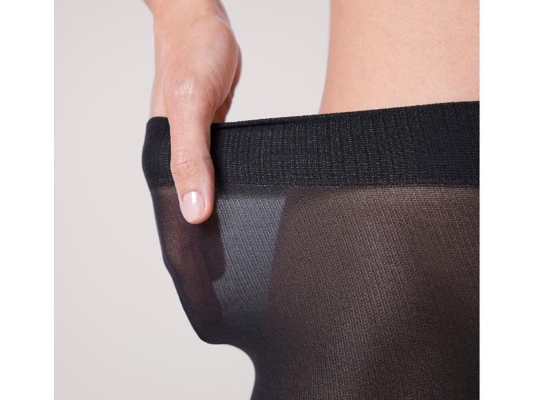 Vrouw past zwarte, dunne panty's.