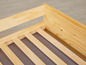 Een houten bedframe met lattenbodem.