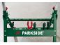 Groene werkbank met gereedschap, waaronder schroevendraaiers en tangen, op een betonnen achtergrond.