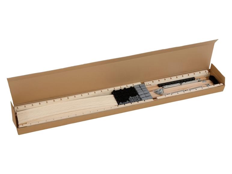 Een open doos met houten latten, metalen onderdelen en plastic elementen voor een bedframe.