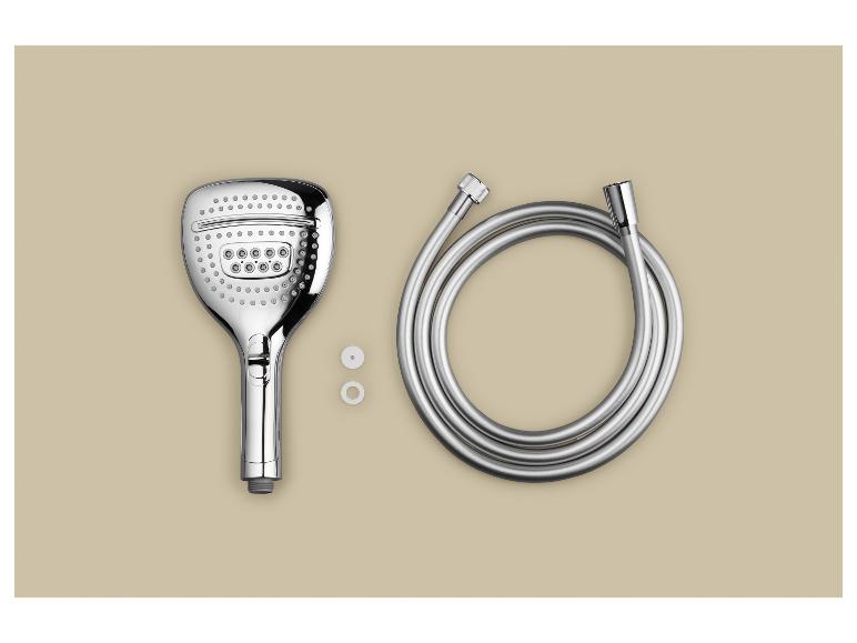 Een chromen douchekop, slang en twee witte ringen op een beige achtergrond.