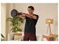 Een man traint thuis met Reebok kettlebells.