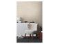Een gezellige kamer met een getextureerd beige behang, een pluizige fauteuil en minimalistische inrichting.