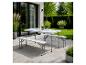 Witte opvouwbare picknicktafel met twee banken op een terras in de tuin.