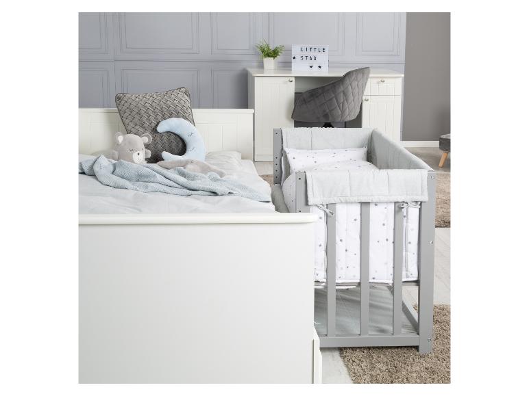 Kinderkamer met wit bed, grijs ledikant en bureau met een 'LITTLE STAR' lamp.