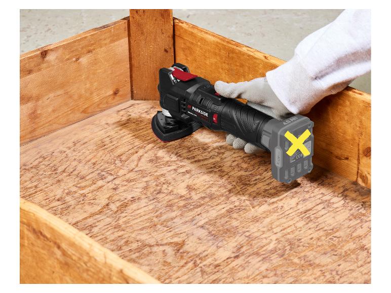 Accu-multitool met accu in houten kist, vastgehouden door een gehandschoende hand.
