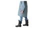 Kind in blauwe regenjas, jeans en zwarte regenlaarzen.