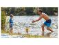 Vader en zoon spelen met een bal in het water, gekleed in zwemkleding.