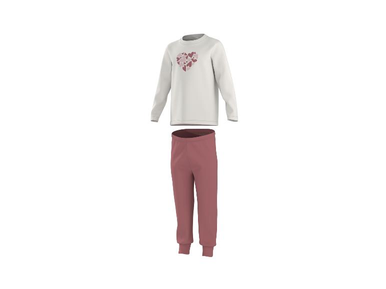 Wit pyjamashirt met lange mouwen en harten, en donkerroze lange pyjamabroek.