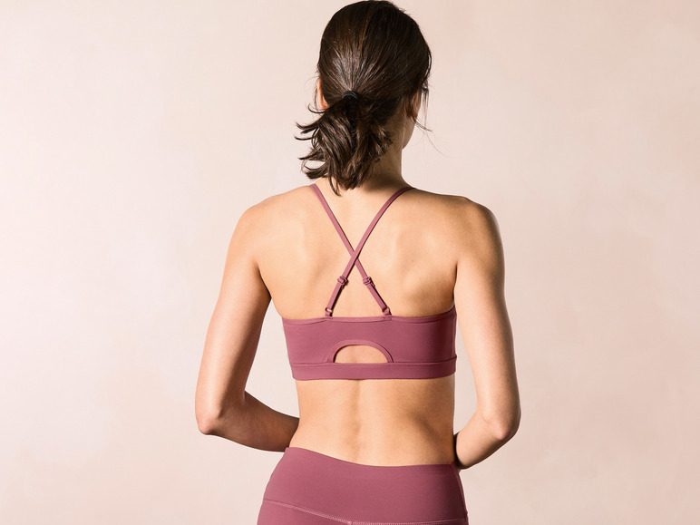 Vrouw draagt een roze sportbeha en leggings.