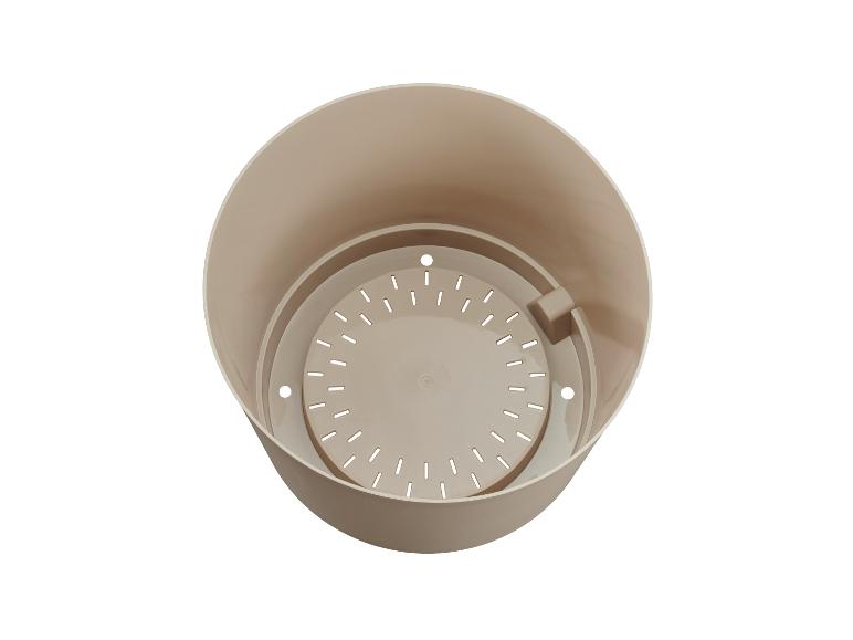 Beige plastic plantenpot met drainage-inzet, van bovenaf gezien.