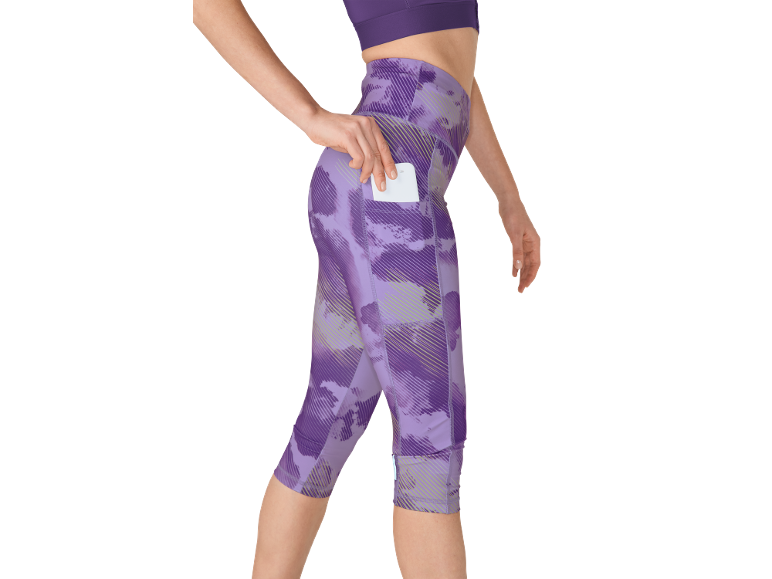Vrouw in paarse bedrukte fitnesslegging, stopt een kaart in de zijzak.