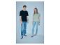 Man in zwart T-shirt en jeans, vrouw in groen T-shirt en jeans.