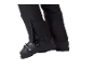 Zwarte skibroek met ritsen over skischoenen.