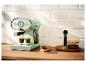 Mintgroene retro koffiemachine zet twee espresso's op een houten aanrecht in een keuken.