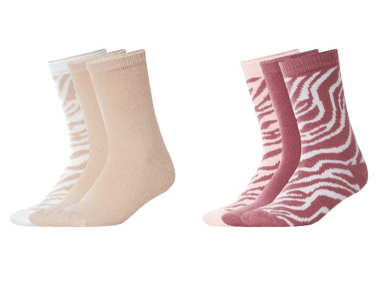 Twee sets sokken: beige en wit, en roze en bordeaux met zebraprint.